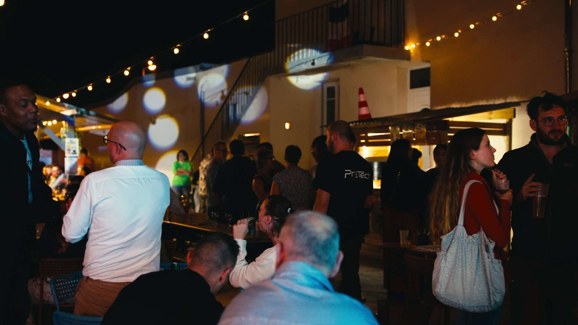 Invités réunis en soirée lors d'un afterwork en plein air