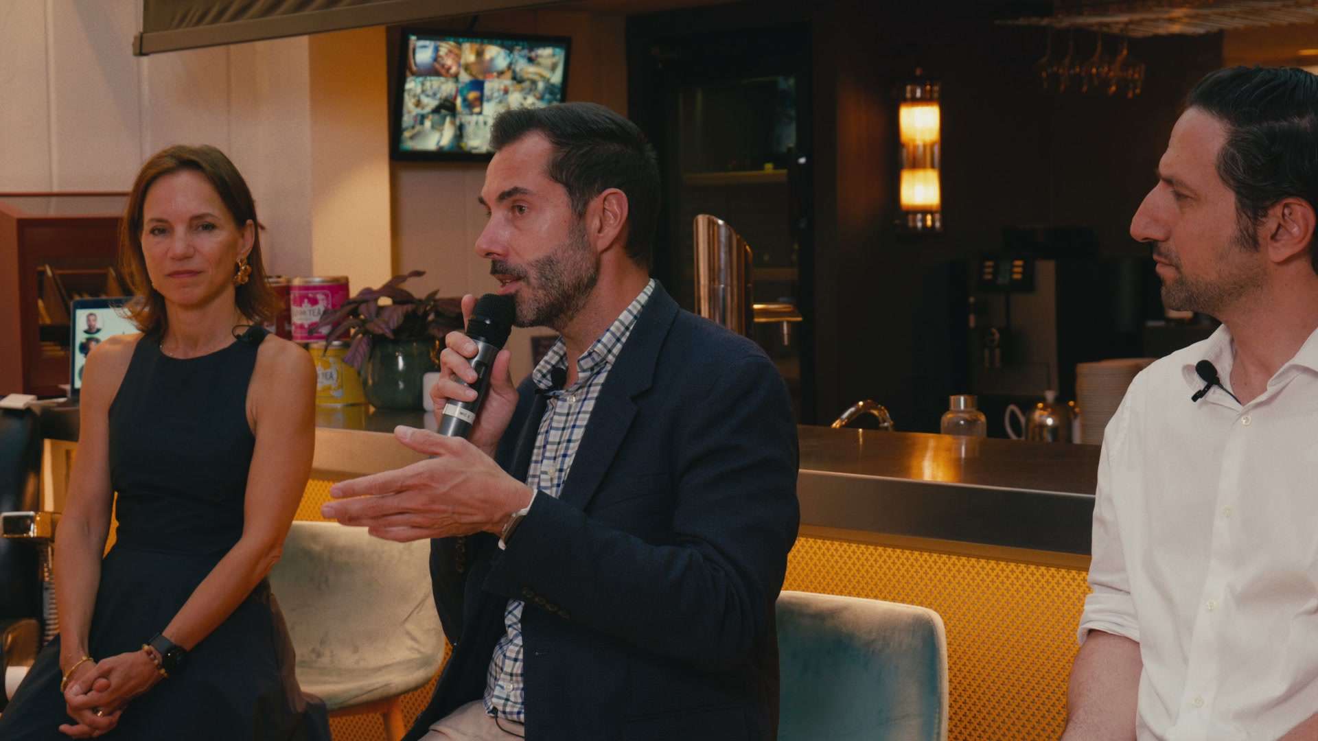 Table ronde filmée dans un showroom café, intervenants au micro
