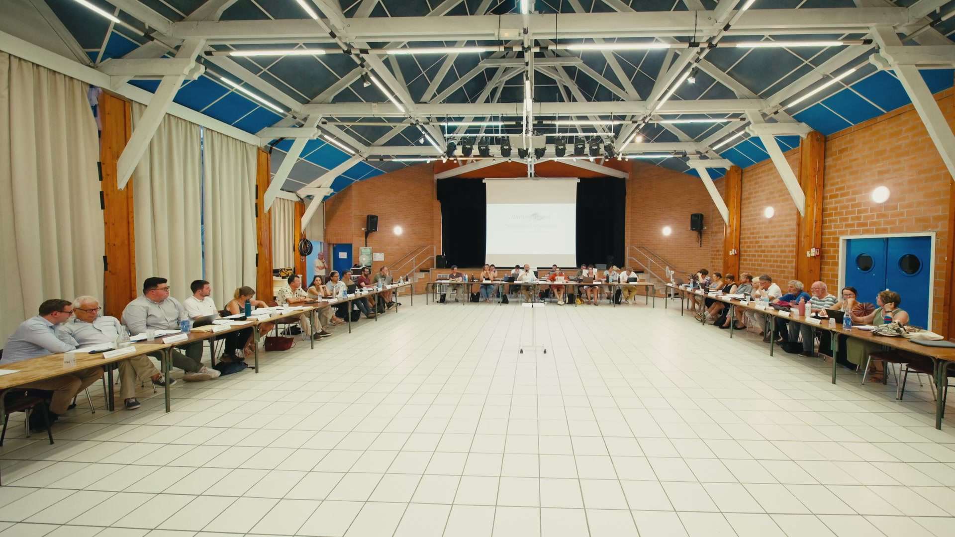 Vue d'ensemble de la salle pendant un conseil municipal de Moret-Loing-et-Orvanne, élus attablés en U