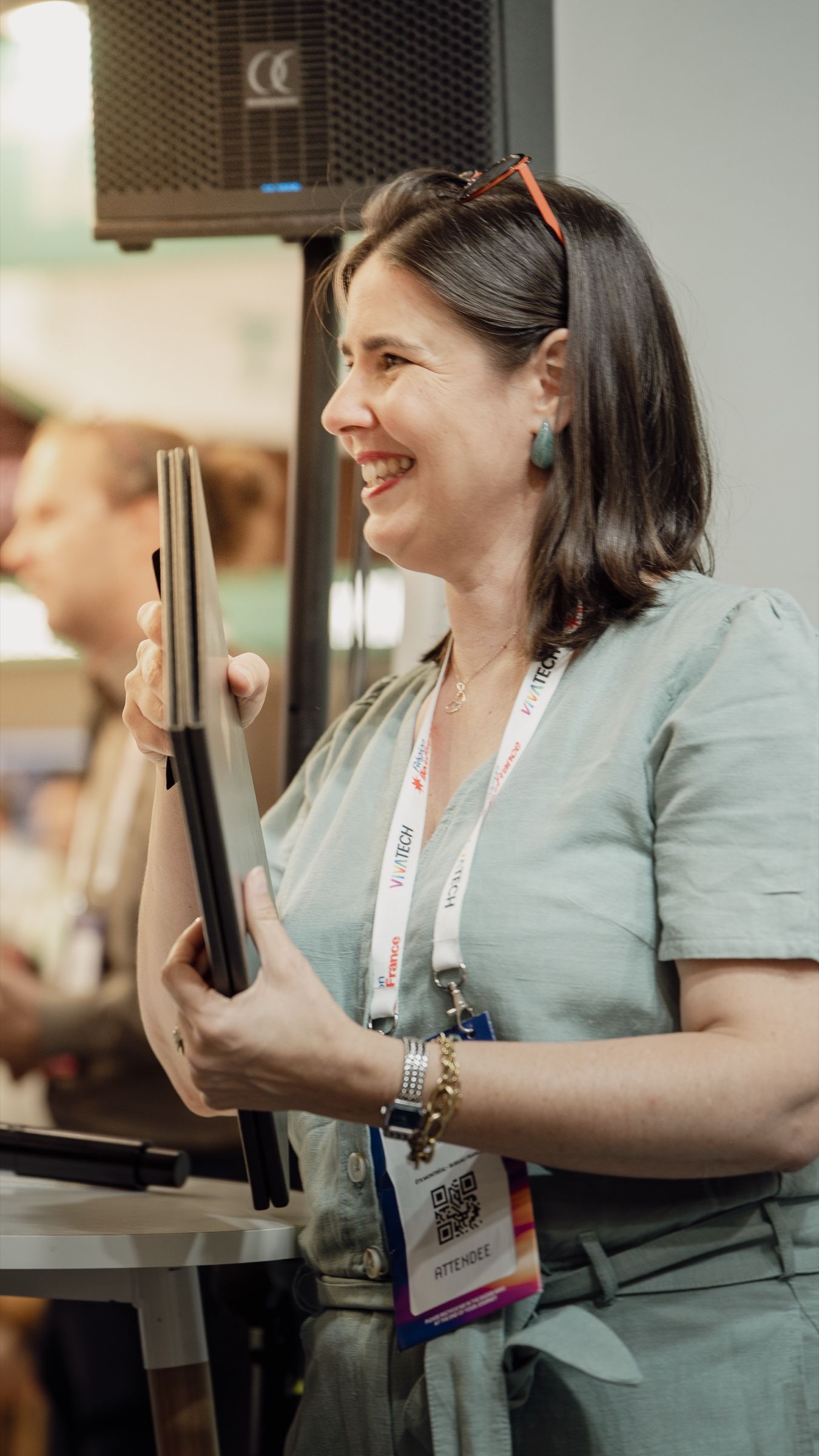 Une participante souriante, document à la main, sur le stand