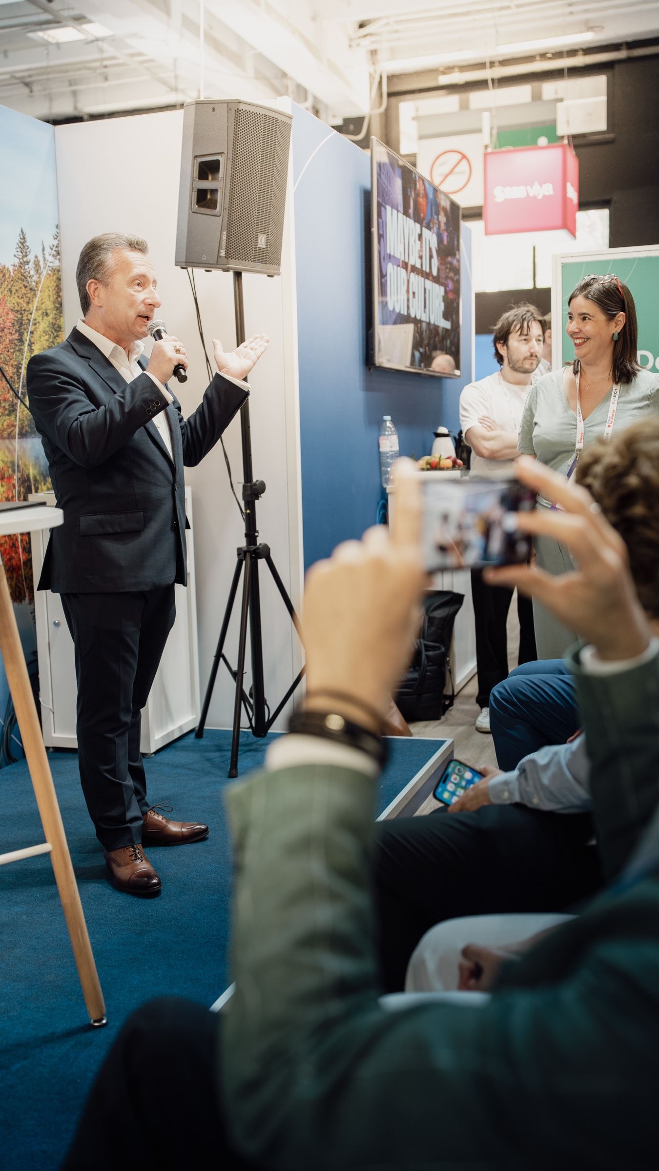 Prise de parole au micro sur le stand, le public filme avec son téléphone