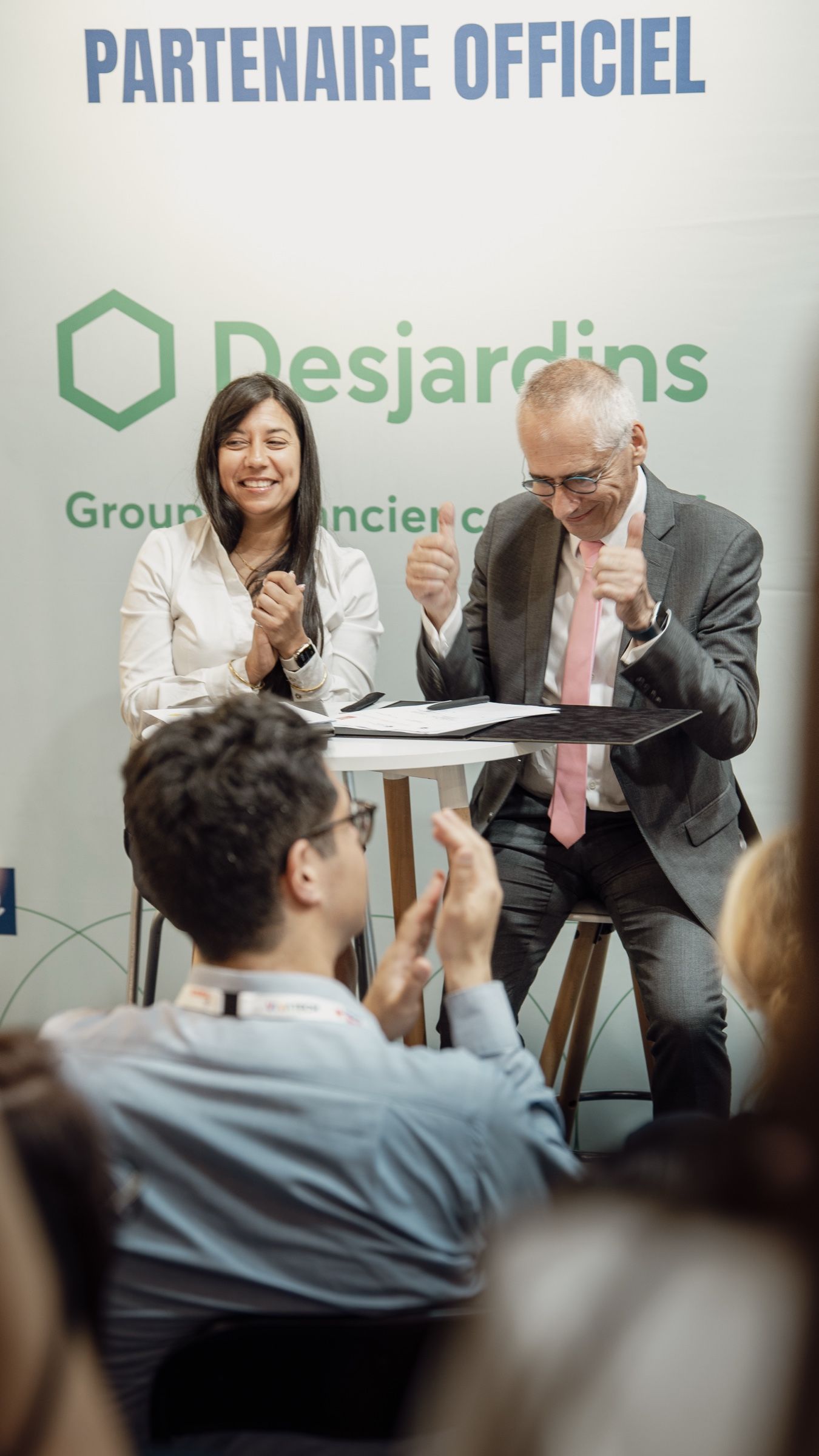 Table ronde sur le stand, devant le panneau partenaire officiel Desjardins